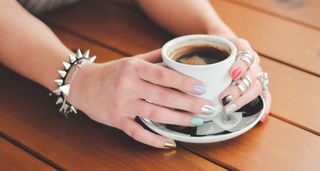 Kaboompics.com_Female-hands-with-jewelry-and-cup-of-coffee-750x400