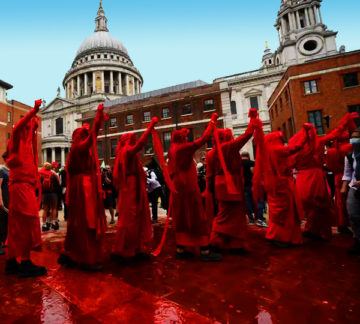 Climate protesters cover a square in central London in fake blood and coins last week. They poured blood-red paint across Chartered Bank’s glass facade, to highlight the $31bn they say it had invested in fossil fuels since the Paris climate accords. Photo: Chris J Ratcliffe/Getty Images