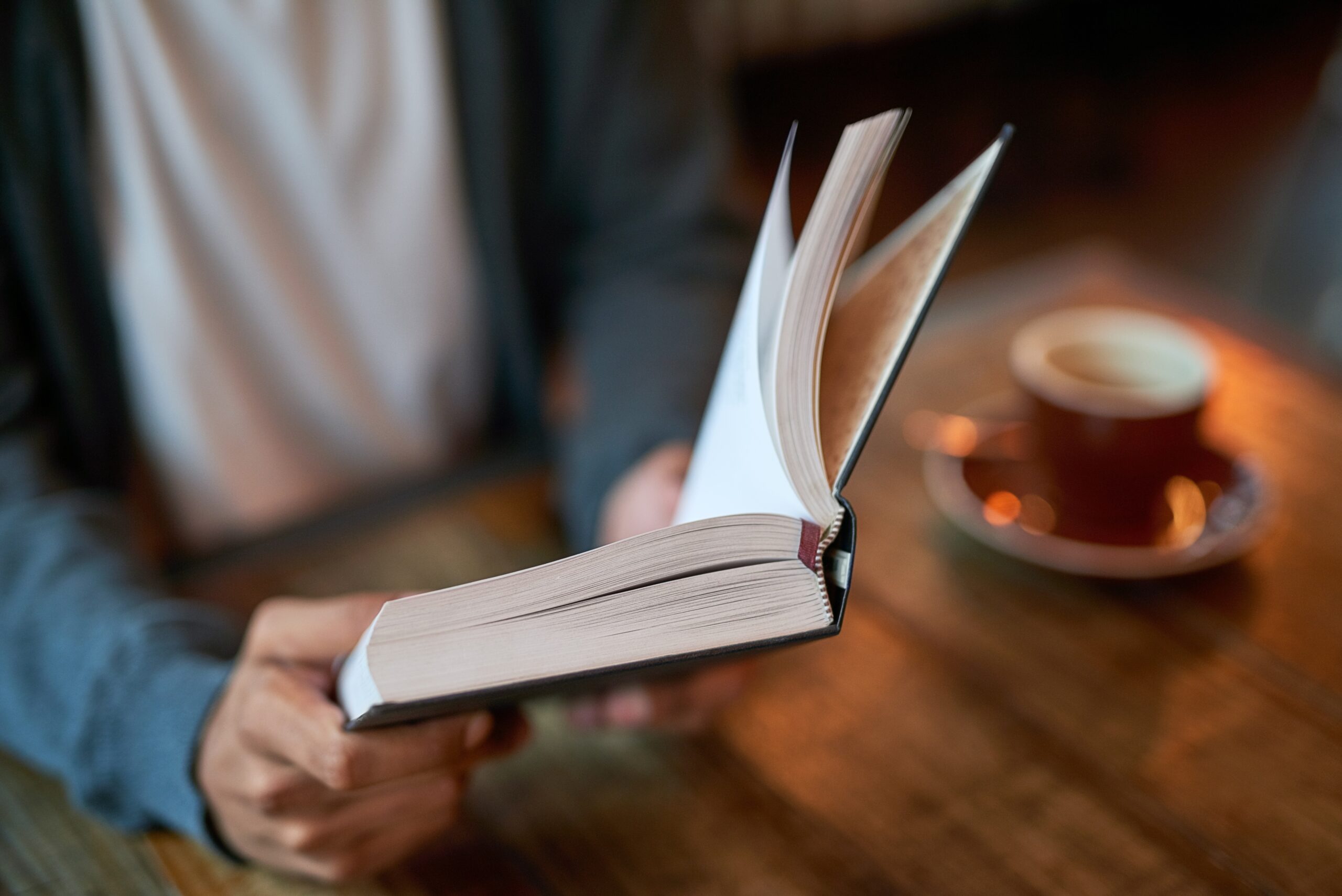 A person reading a book at a cafe