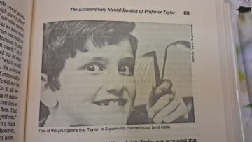 Black-and-white photograph of a young person holding up a sharply bent metal object.